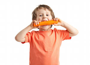boy eating carrot An Easy Way to Get Your Kids to Eat More Fruits & Vegetables
